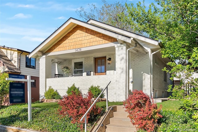 view of front of home featuring a porch and brick siding
