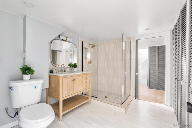 bathroom featuring a shower stall, vanity, and toilet