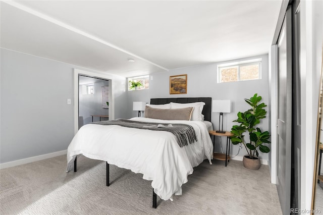 bedroom featuring light colored carpet and baseboards