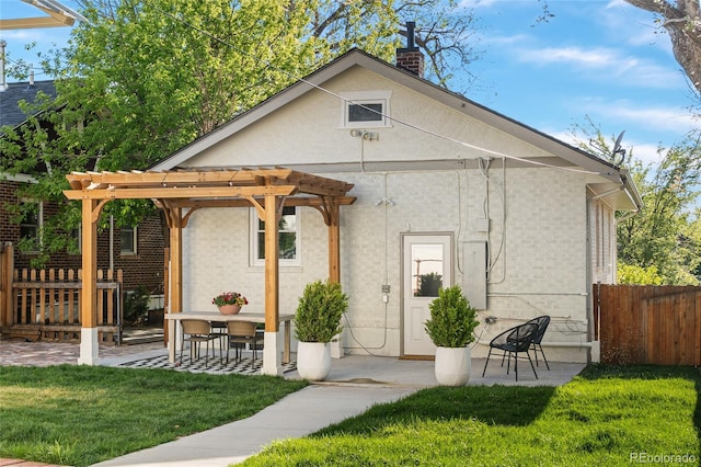 view of front of home featuring a pergola, a chimney, and a patio area