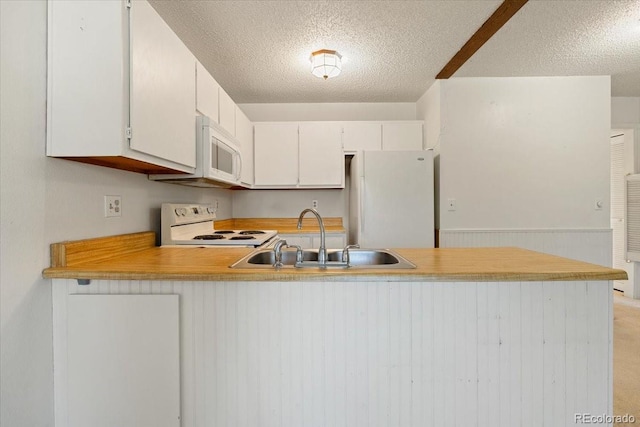 kitchen with sink, white cabinets, white appliances, kitchen peninsula, and a textured ceiling