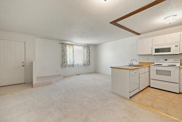 kitchen with sink, white appliances, white cabinets, light colored carpet, and kitchen peninsula