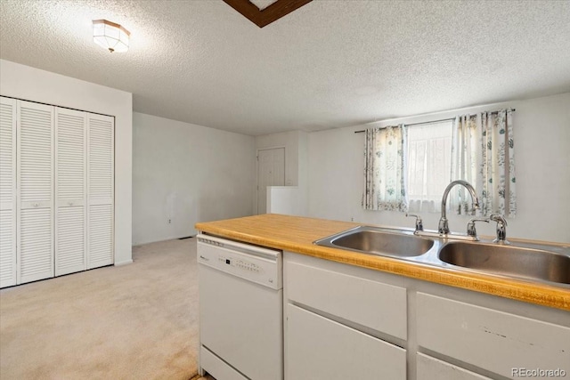 kitchen with white dishwasher, sink, light carpet, and a textured ceiling