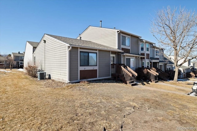 rear view of house with a yard and central AC