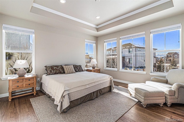 bedroom featuring ornamental molding, dark hardwood / wood-style floors, and a tray ceiling