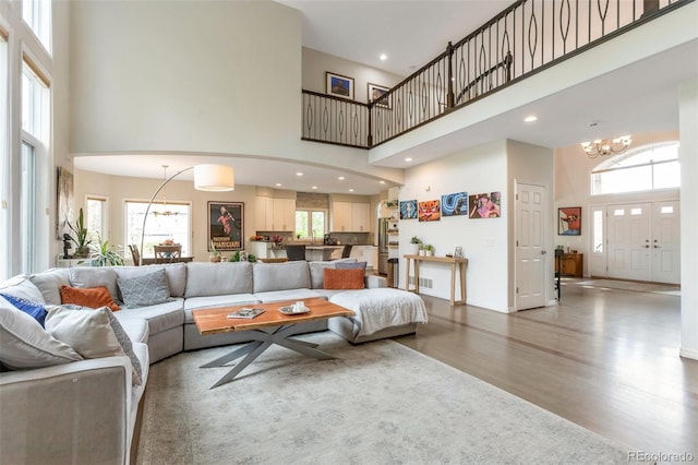 10773 Cougar Rdg, Lone Tree, CO 80124 - living room with a high ceiling, a chandelier, wood finished floors, and recessed lighting