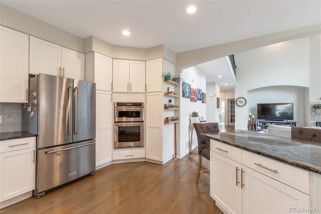 10773 Cougar Rdg, Lone Tree, CO 80124 - kitchen with stainless steel appliances, dark wood-style floors, white cabinetry, dark stone countertops, and recessed lighting