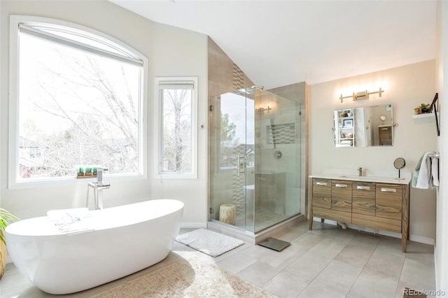 10773 Cougar Rdg, Lone Tree, CO 80124 - full bath with vanity, a shower stall, a freestanding tub, vaulted ceiling, and baseboards