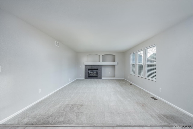 unfurnished living room with light carpet and a fireplace