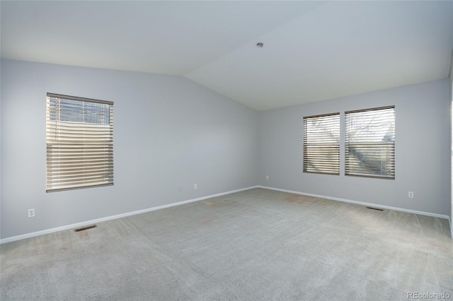 carpeted empty room with lofted ceiling