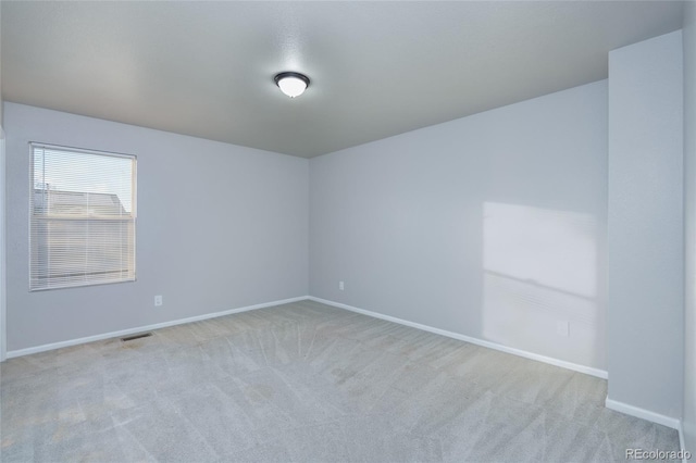 spare room featuring light colored carpet