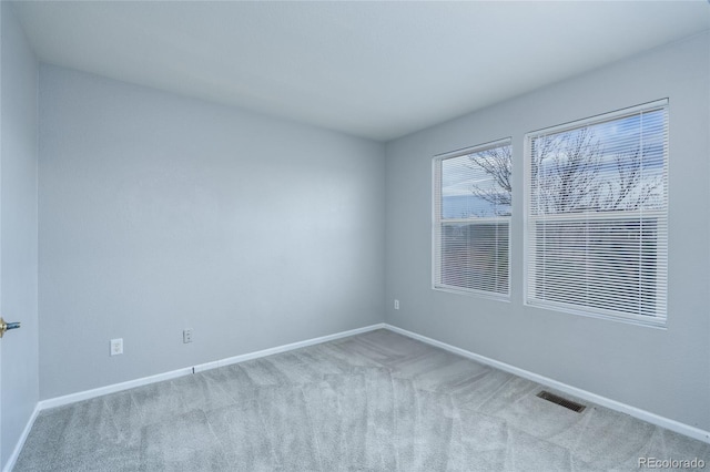 unfurnished room featuring light carpet