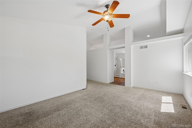 carpeted spare room featuring a ceiling fan, baseboards, and vaulted ceiling