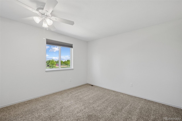 carpeted empty room with a ceiling fan and baseboards