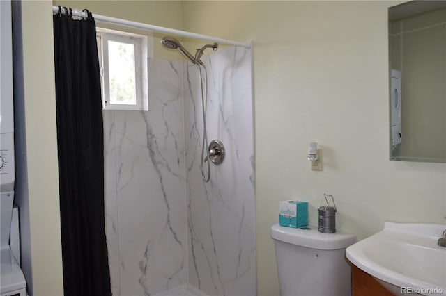 bathroom with toilet, vanity, and a tile shower