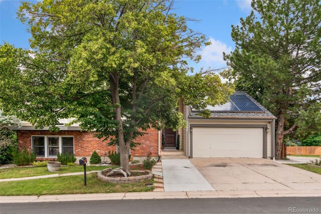 3390 S Ensenada Way, Aurora, CO 80013 - obstructed view of property with concrete driveway, an attached garage, solar panels, and brick siding
