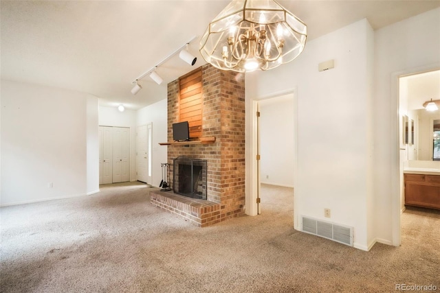 5010 Sunsuite Trl, Colorado Springs, CO 80917 - unfurnished living room featuring carpet flooring, a chandelier, a brick fireplace, and baseboards