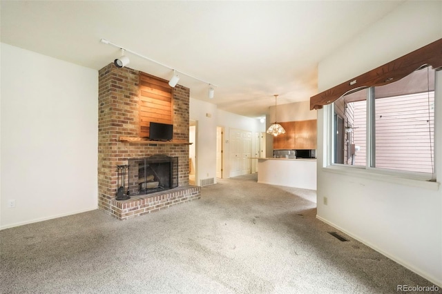 5010 Sunsuite Trl, Colorado Springs, CO 80917 - unfurnished living room with track lighting, carpet floors, a fireplace, and baseboards
