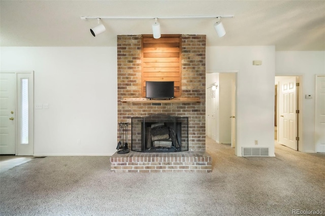 5010 Sunsuite Trl, Colorado Springs, CO 80917 - unfurnished living room with track lighting, carpet flooring, and a brick fireplace