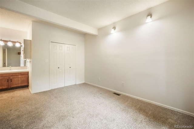 5010 Sunsuite Trl, Colorado Springs, CO 80917 - unfurnished bedroom with light carpet, ensuite bathroom, a sink, baseboards, and a closet