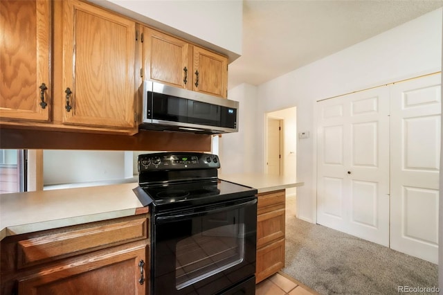 5010 Sunsuite Trl, Colorado Springs, CO 80917 - kitchen with black / electric stove, stainless steel microwave, light carpet, and light countertops
