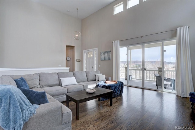 living room featuring a wealth of natural light, a chandelier, and wood finished floors