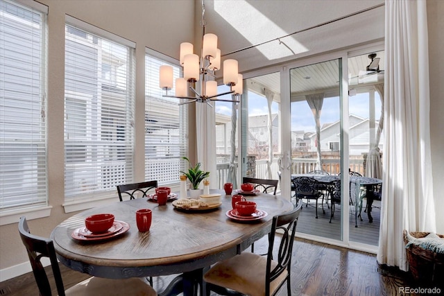 dining room with a notable chandelier, dark wood-style floors, and baseboards