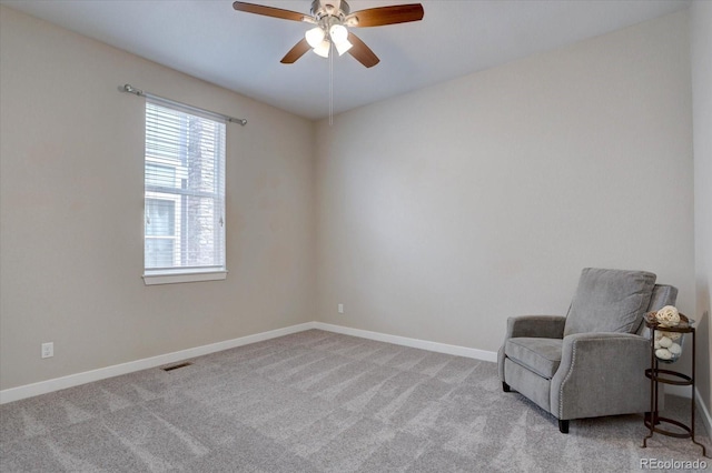 sitting room with visible vents, baseboards, carpet, and ceiling fan