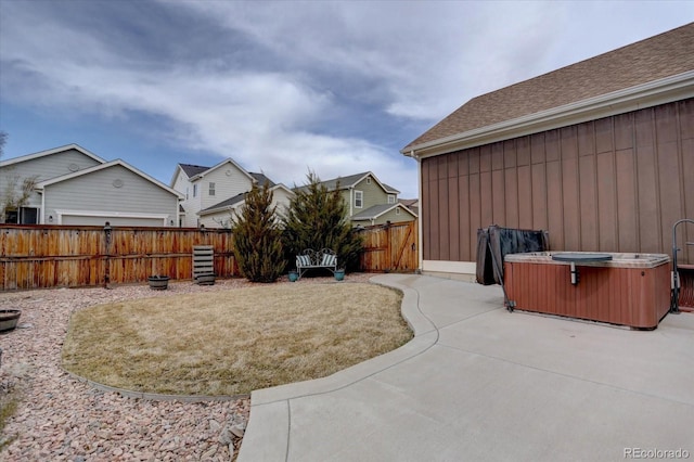 view of yard featuring a patio, fence, and a hot tub