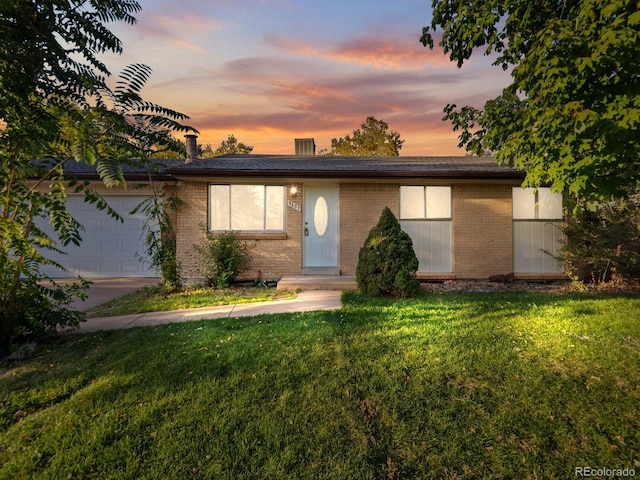 view of front of property featuring a garage and a lawn