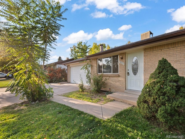 single story home featuring a garage and a front lawn