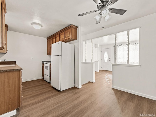 kitchen with ceiling fan, white appliances, sink, and light hardwood / wood-style floors