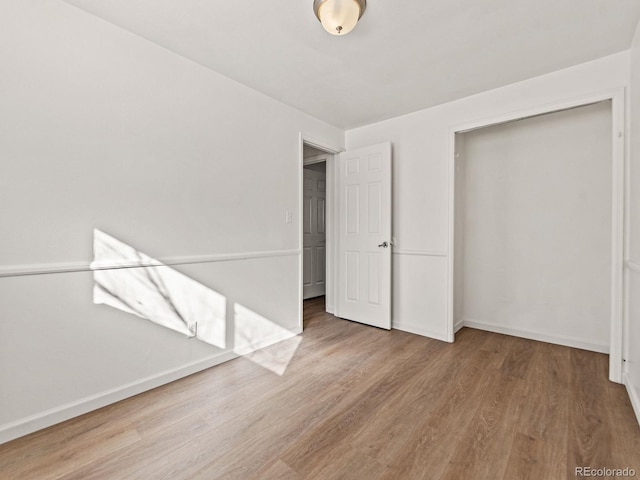 unfurnished bedroom with wood-type flooring and a closet