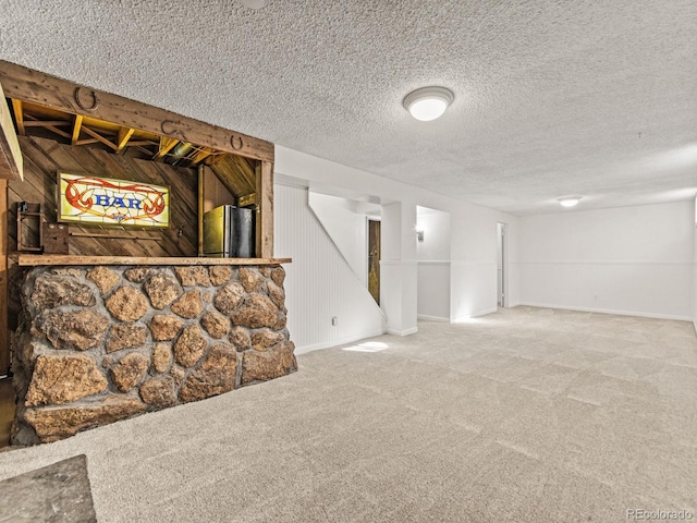 basement with carpet flooring, wooden walls, and a textured ceiling