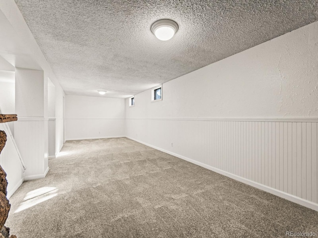 basement featuring carpet floors and a textured ceiling