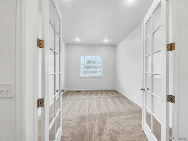 empty room with light colored carpet and french doors