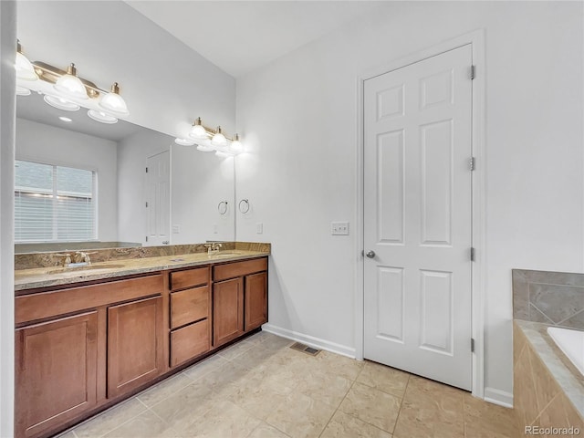 bathroom with a relaxing tiled tub, tile patterned floors, and vanity