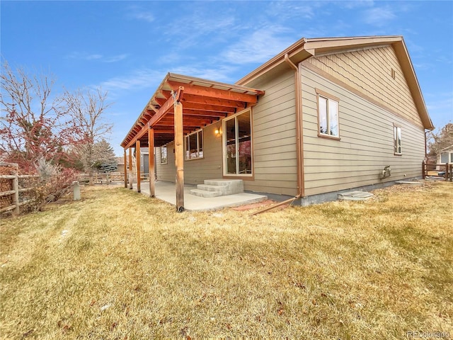 view of property exterior with a yard and a patio