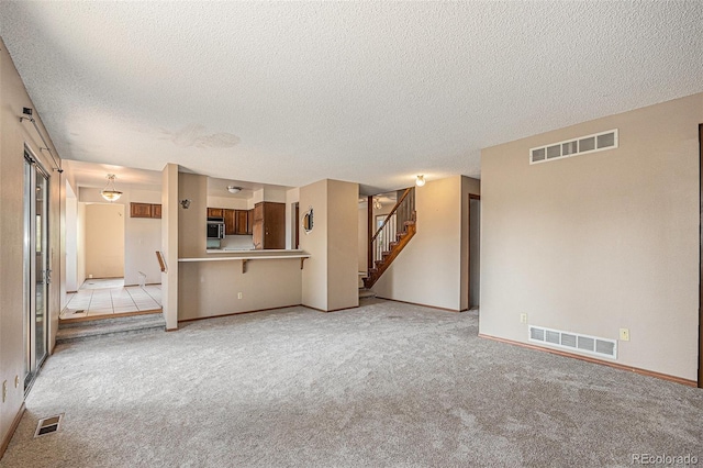 17583 E Belleview Pl, Centennial, CO 80015 - unfurnished living room with a textured ceiling, light carpet, and stairway