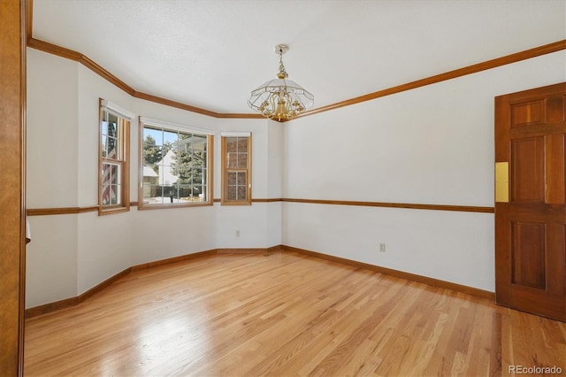 spare room with light wood-type flooring, an inviting chandelier, and ornamental molding