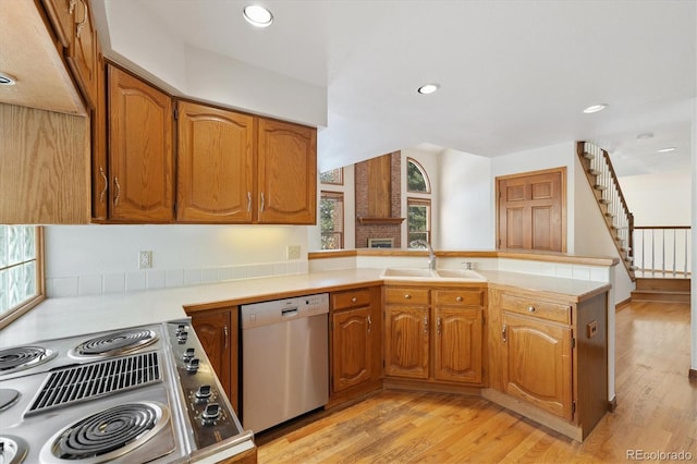 kitchen featuring stove, dishwasher, kitchen peninsula, and sink