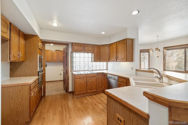 kitchen featuring hanging light fixtures, kitchen peninsula, sink, and stainless steel appliances