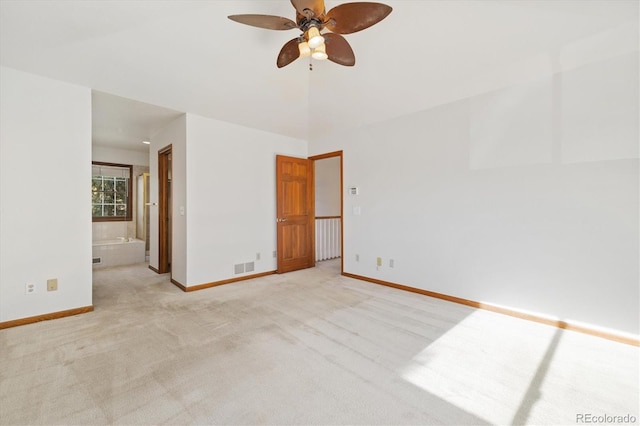 unfurnished bedroom with ceiling fan, light colored carpet, and connected bathroom