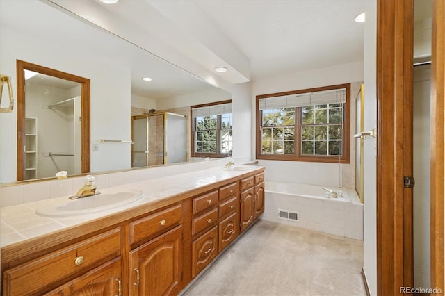 bathroom featuring vanity and shower with separate bathtub