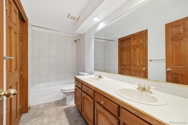 full bathroom with toilet, tiled shower / bath combo, and vanity