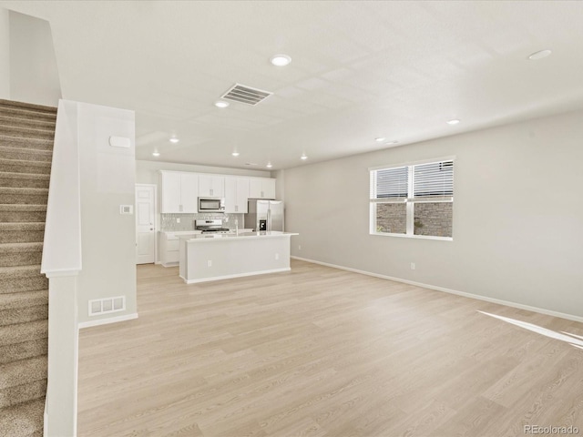 20982 E 66th Ave, Aurora, CO 80019 - unfurnished living room featuring stairway, baseboards, visible vents, and light wood-style flooring