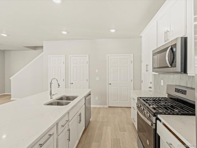 20982 E 66th Ave, Aurora, CO 80019 - kitchen featuring white cabinets, a sink, light wood-style floors, and appliances with stainless steel finishes