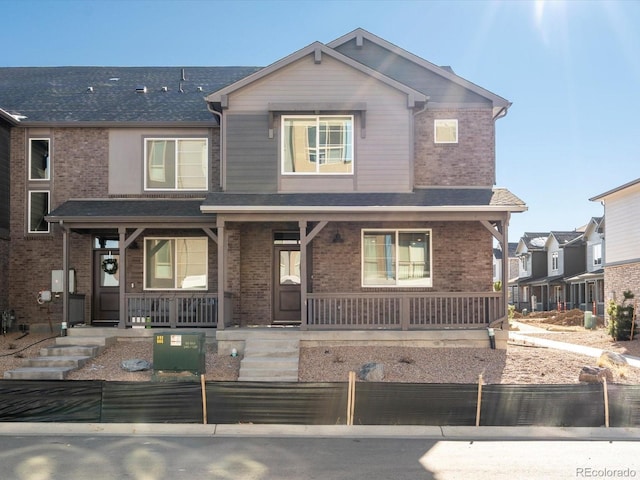 20982 E 66th Ave, Aurora, CO 80019 - view of front facade with a shingled roof, fence private yard, covered porch, and brick siding