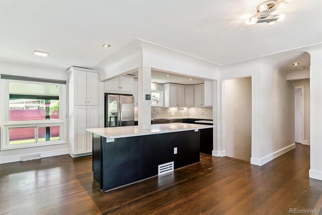 5480 W Iowa Ave, Lakewood, CO 80232 - kitchen with stainless steel refrigerator with ice dispenser, light countertops, a kitchen island, and dark wood-style flooring