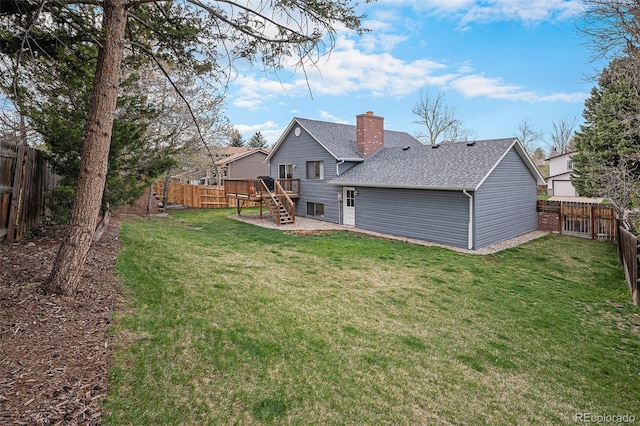 7746 W Quarto Dr, Littleton, CO 80128 - back of property featuring roof with shingles, a fenced backyard, a wooden deck, stairs, and a yard